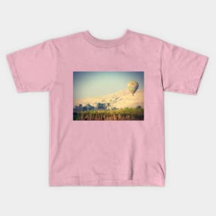 hot air balloon over a traditional village in the Egyptian countryside Kids T-Shirt